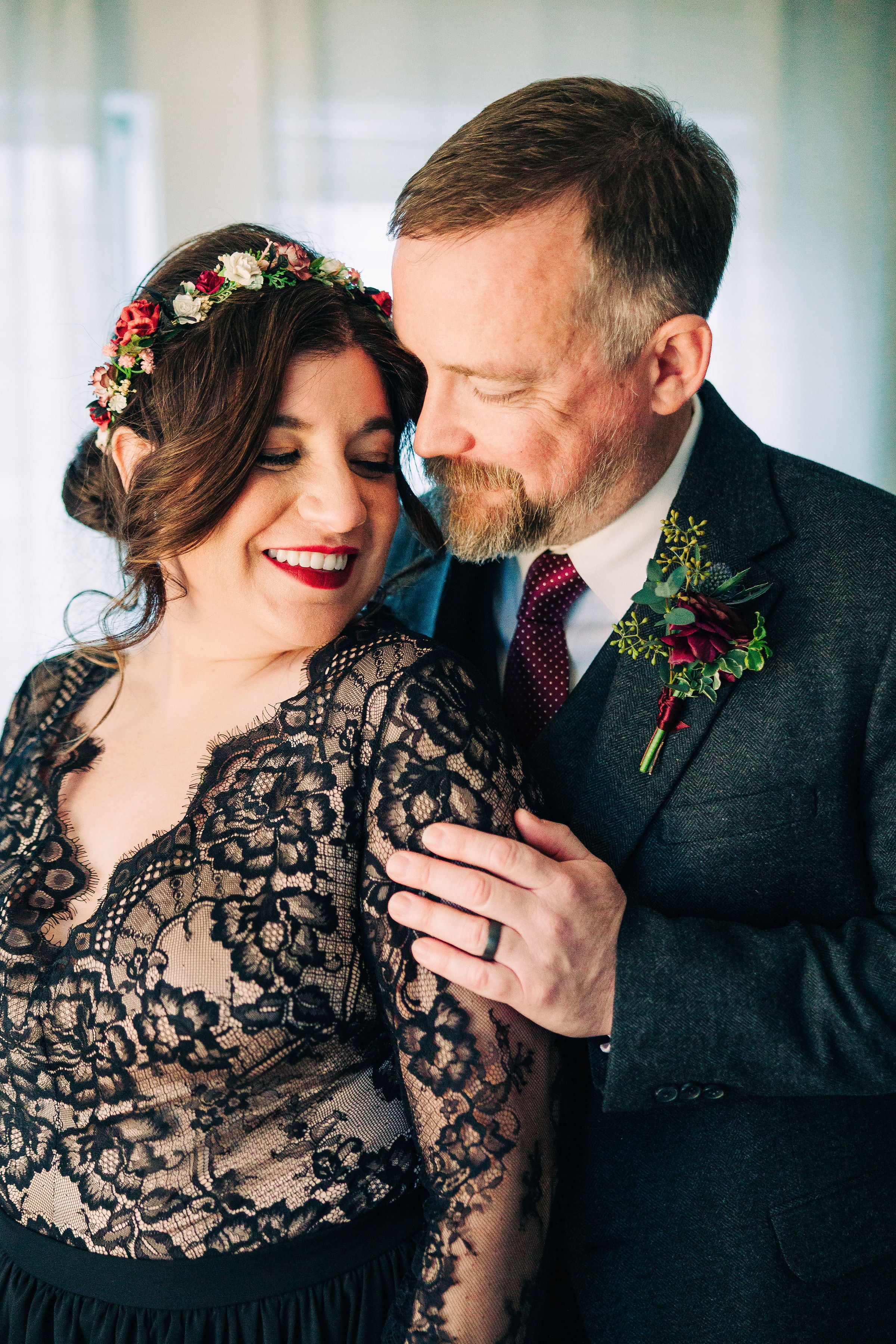 Jenn and Billy cozied up in the bridal suite lit by warm lamp lighting as they share an intimate embrace