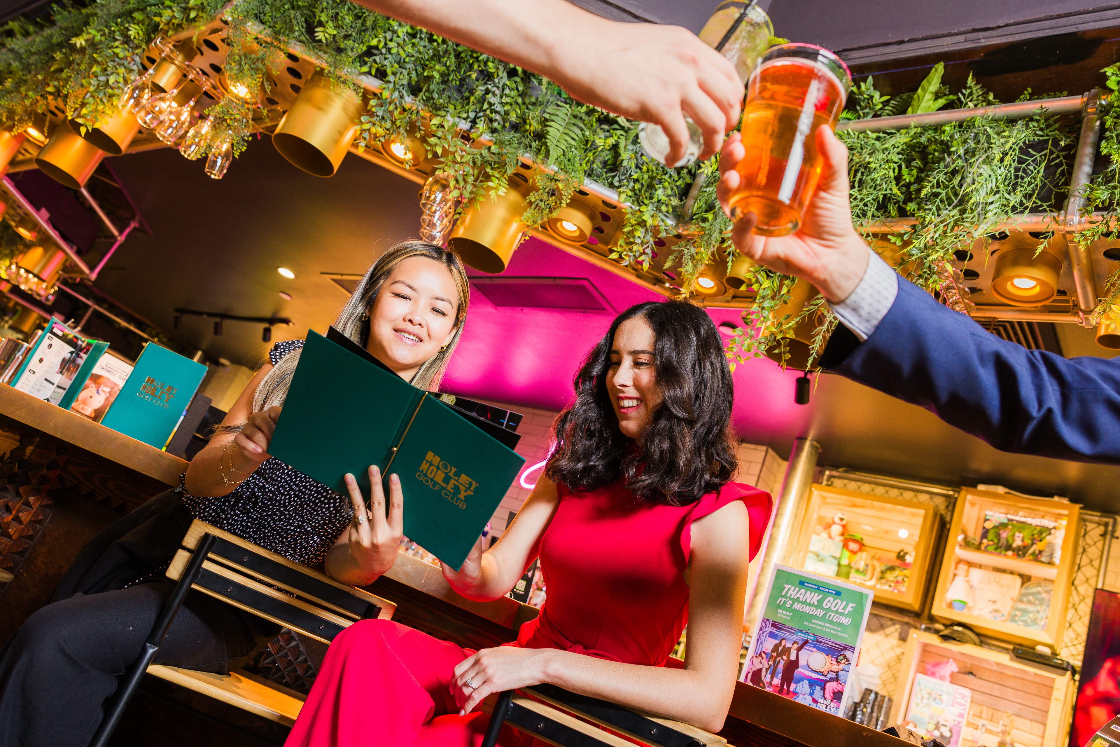 a strong hero image of multiple models posing as corporate employees at an event, laughing over appetizers in a vibrant, neon, well lit room