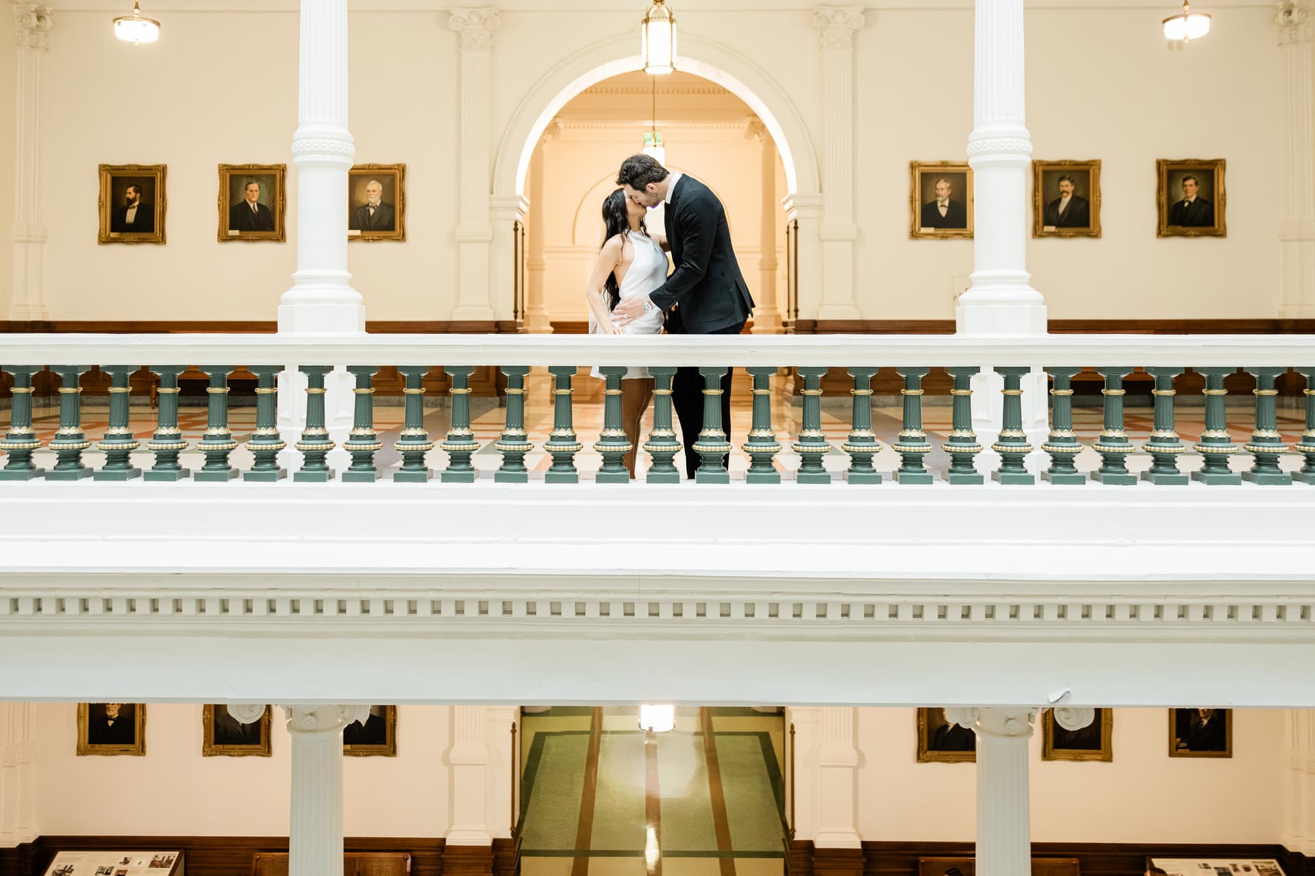 Newlyweds on the south steps of the Texas Capitol, the pink granite dome rising behind them