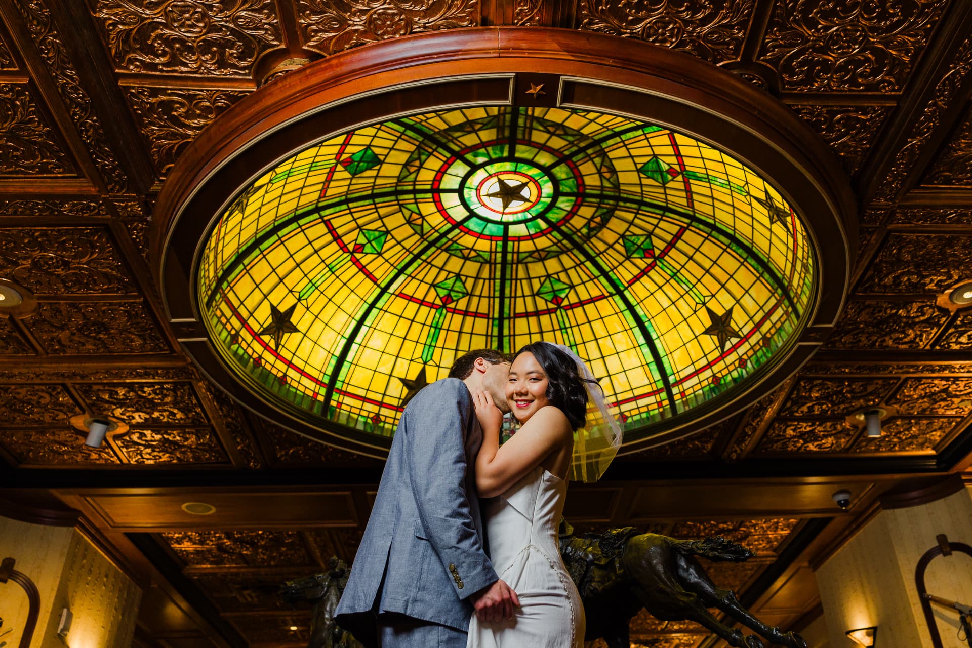 Newlyweds posing for portraits in the historic downtown Driskill hotel, warm interior light