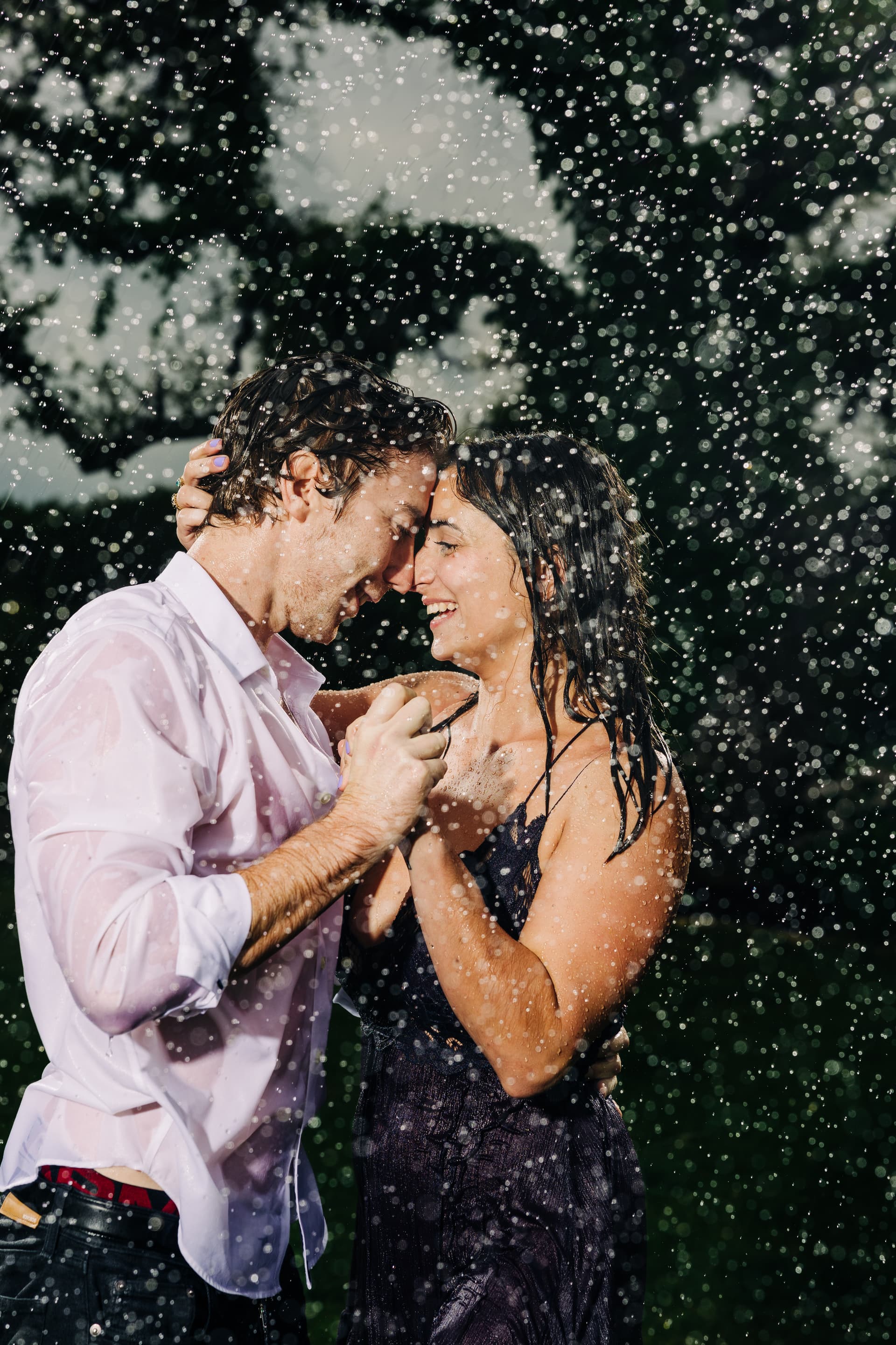 Couple mid-motion during an engagement session — spinning & laughing while dancing together with outfits flowing naturally with the movement