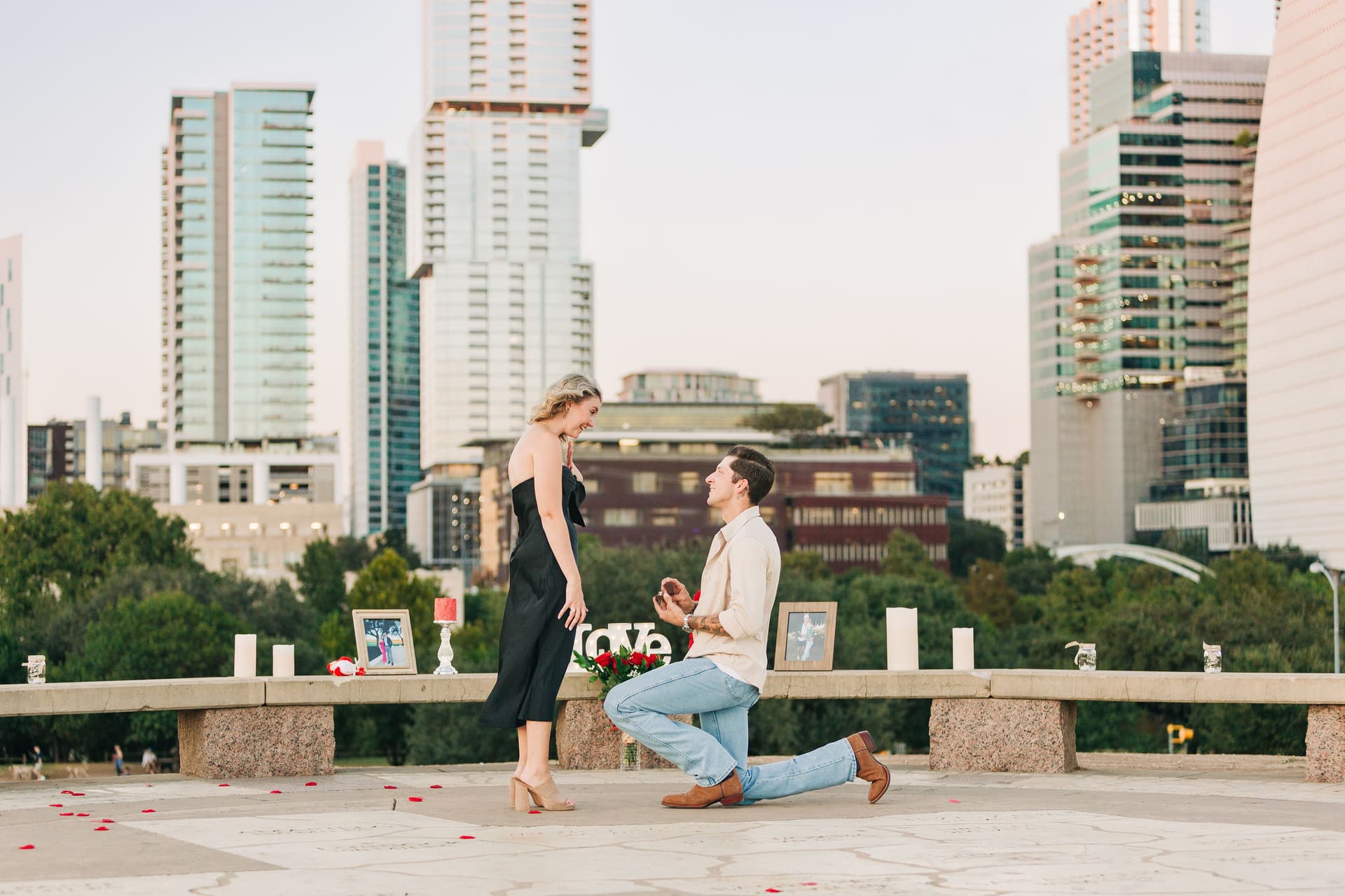 Couple embracing after proposal at Auditorium Shores during golden hour with Austin skyline reflected in Lady Bird Lake